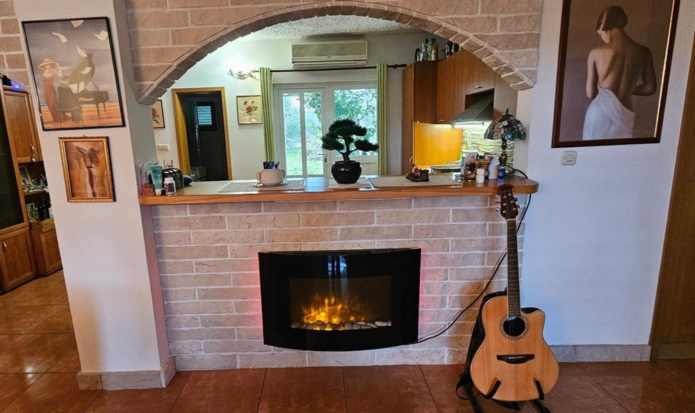 Öppen spis med gitarr och väggmålningar