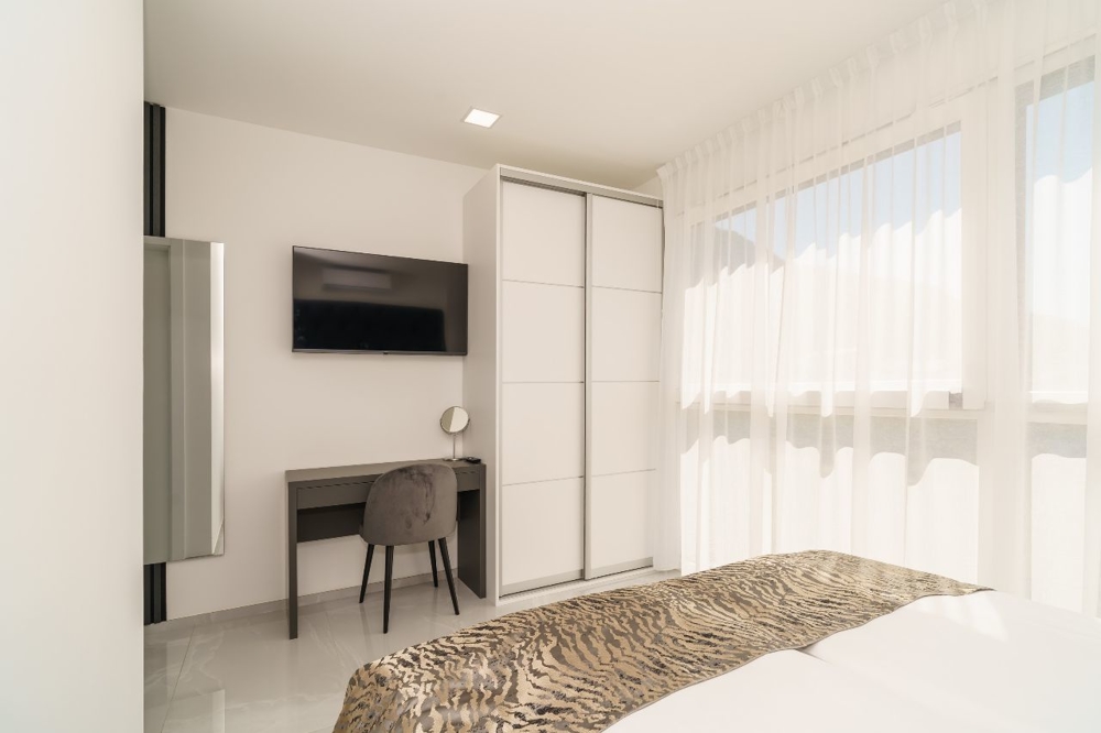 Ljust sovrum med skrivbord och TV