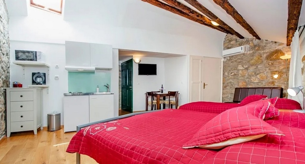 Studio med stenvägg, dubbelsäng och pentry