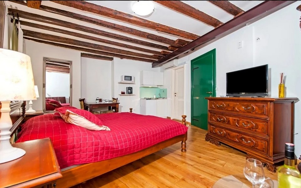 Mysig studio med grön entré och TV