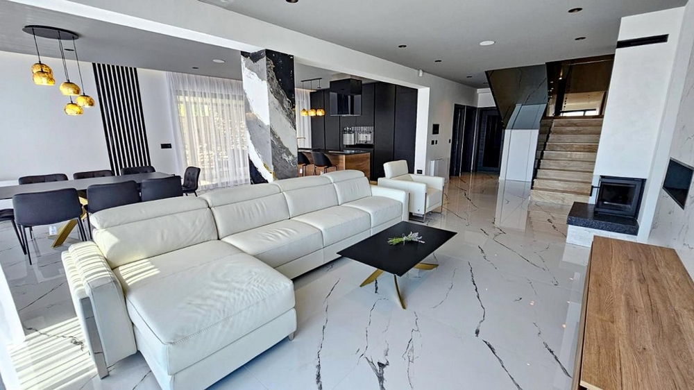 Vardagsrum med ljus soffa och öppen spis