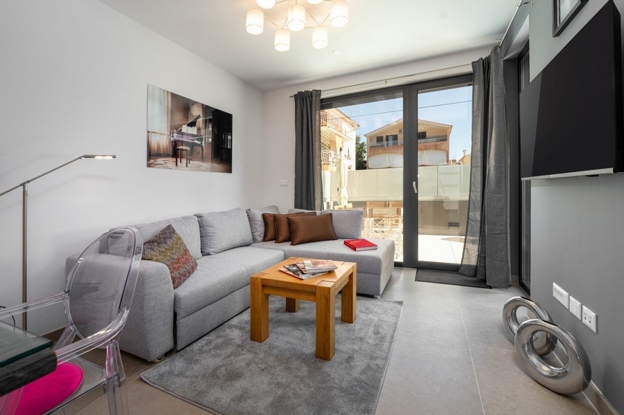 Vardagsrum med hörnsoffa och utgång till terrassen