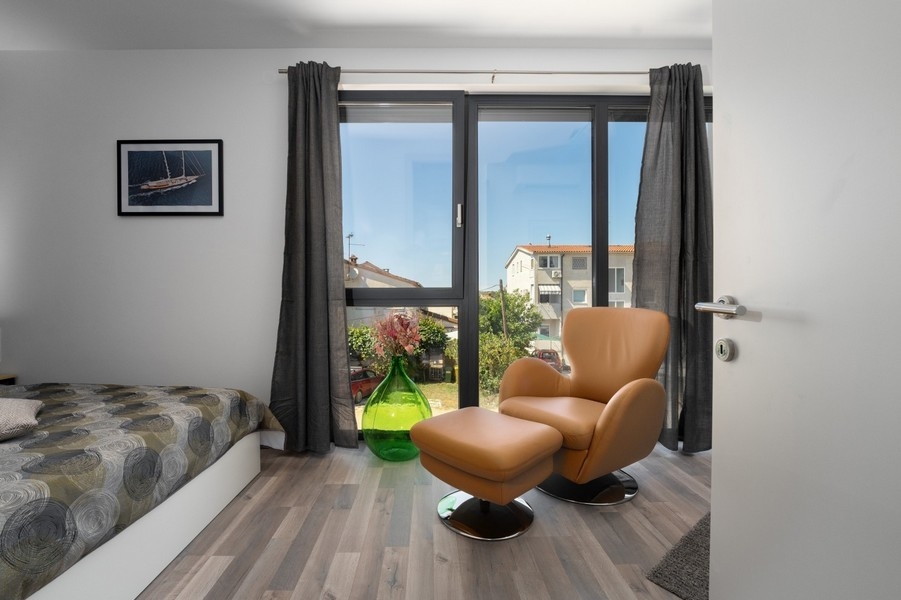 Sovrum med fåtölj och stort fönster