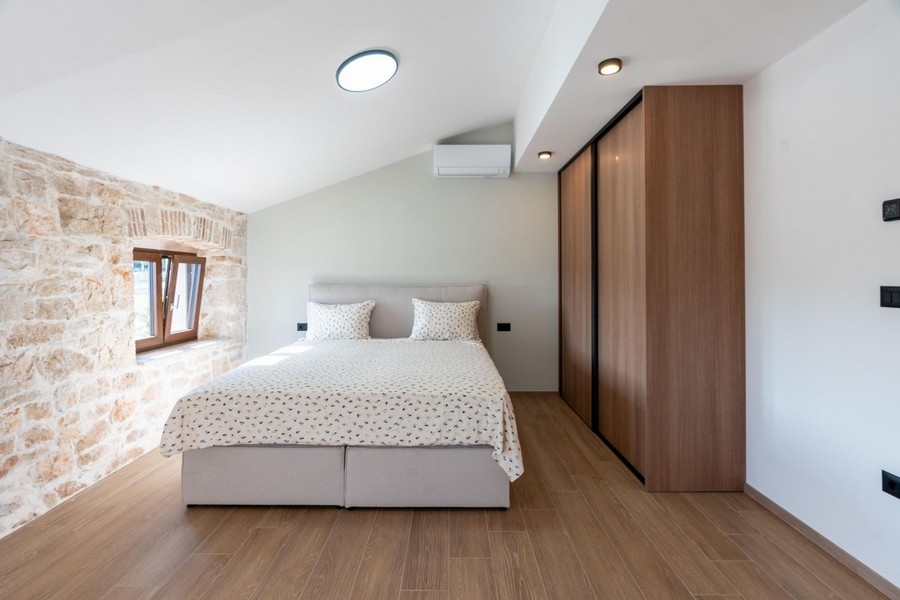 Ljust sovrum med naturstensvägg
