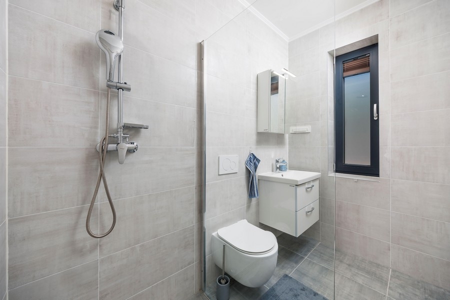 Modernt badrum med dusch och fönster