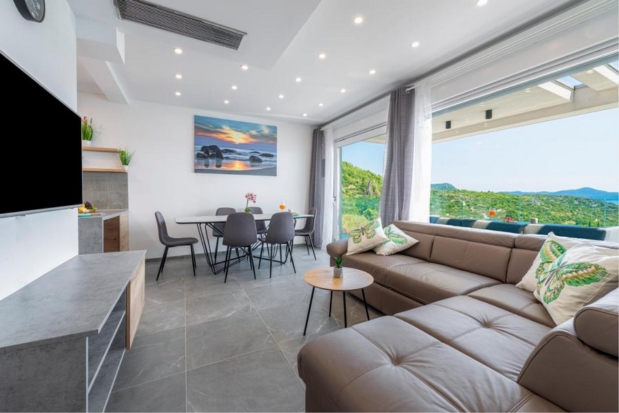 Ljust vardagsrum med stora fönsterpartier och panoramautsikt