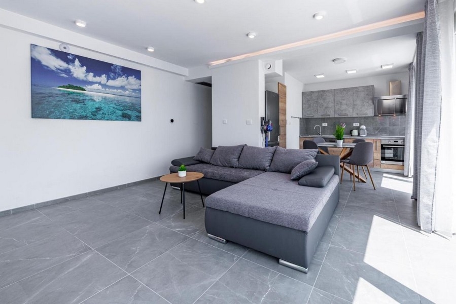 Modernt vardagsrum med soffa och öppet kök