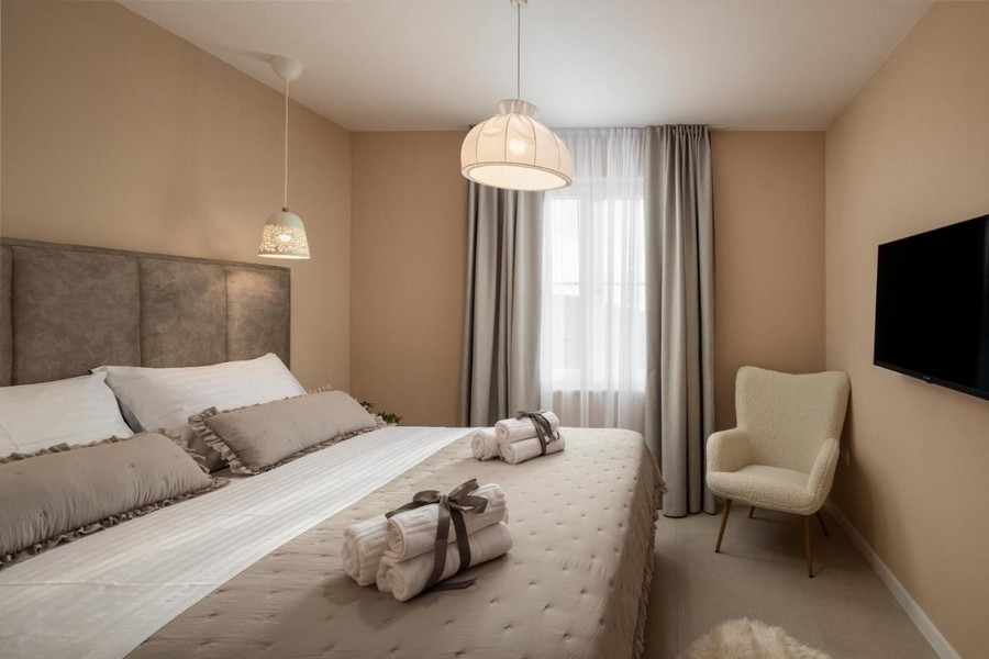 Sovrum med dubbelsäng, TV och fåtölj