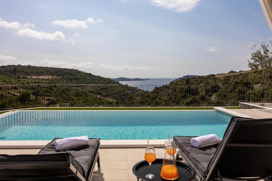 Infinitypool med havsutsikt och solstolar