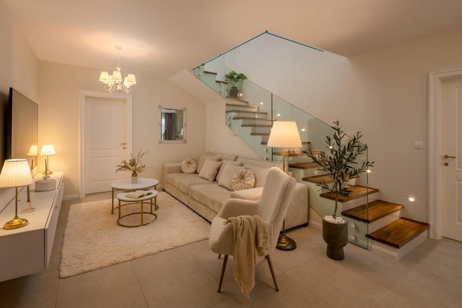 Vardagsrum med soffa och modern trappa