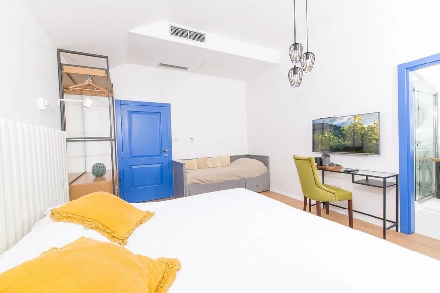 Sovrum med dubbelsäng, skrivbord och tv