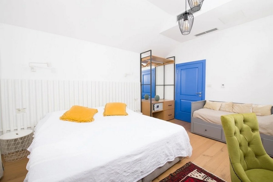 Sovrum med dubbelsäng, blå dörr och garderob