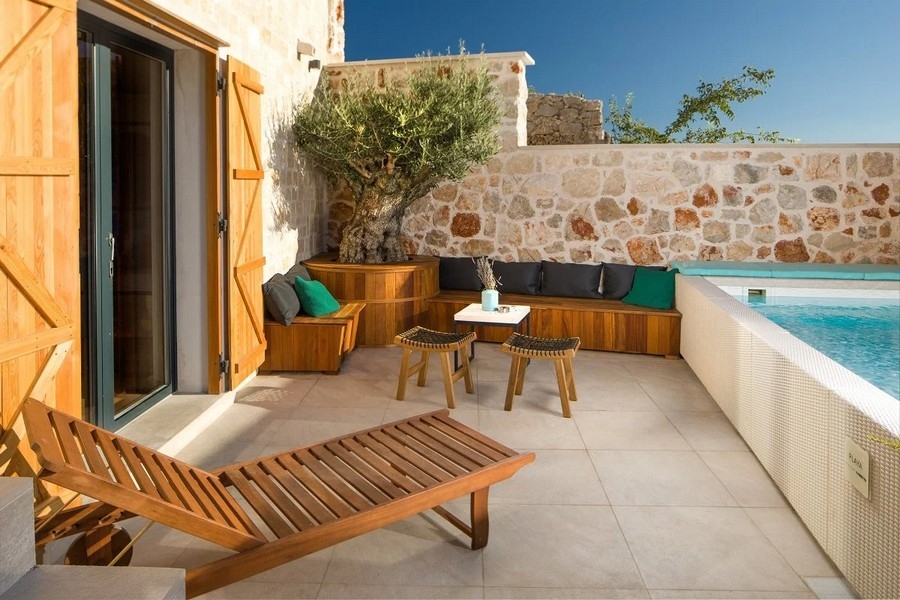 Terrass med pool, trästolar och bänk