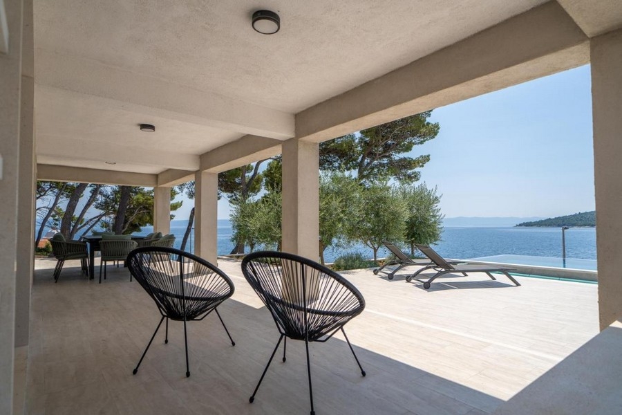 Täckt terrass med sittgrupp och havsutsikt