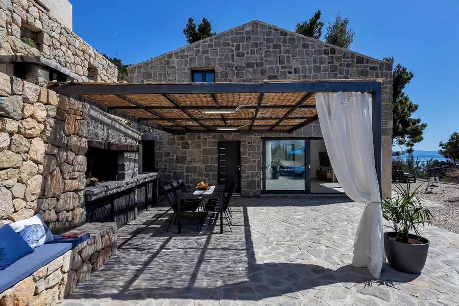 Övertäckt terrass med matplats och grill