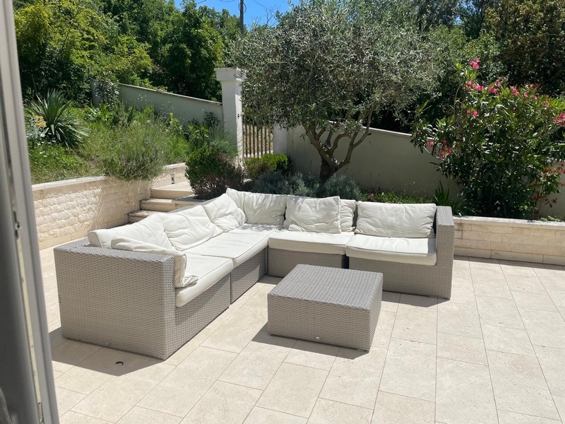 Trädgårdsterrass med sittgrupp och olivträd