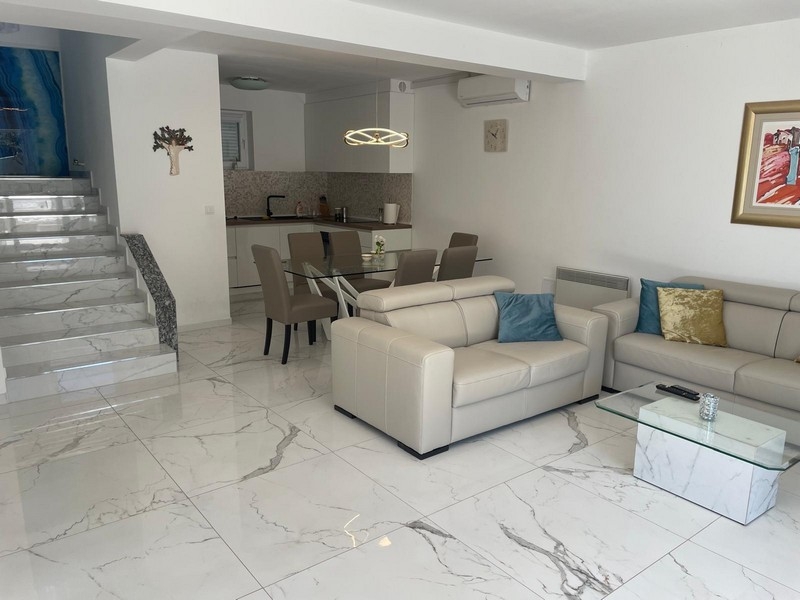 Modernt vardagsrum med öppet kök och matplats