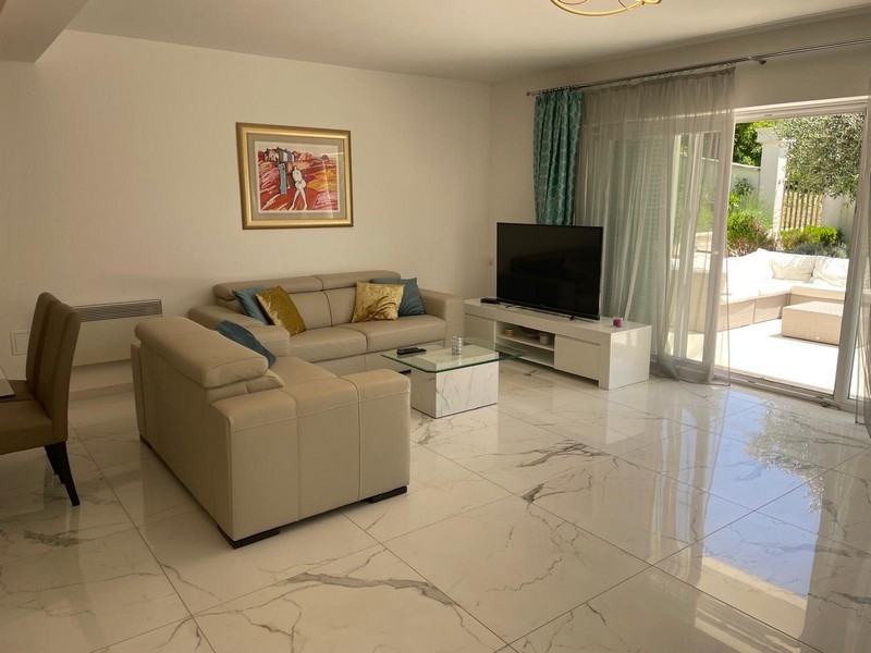 Ljust vardagsrum med utgång till altan