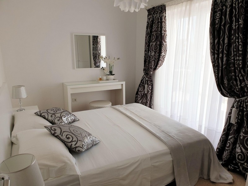 Sovrum med dubbelsäng och fönster från golv till tak