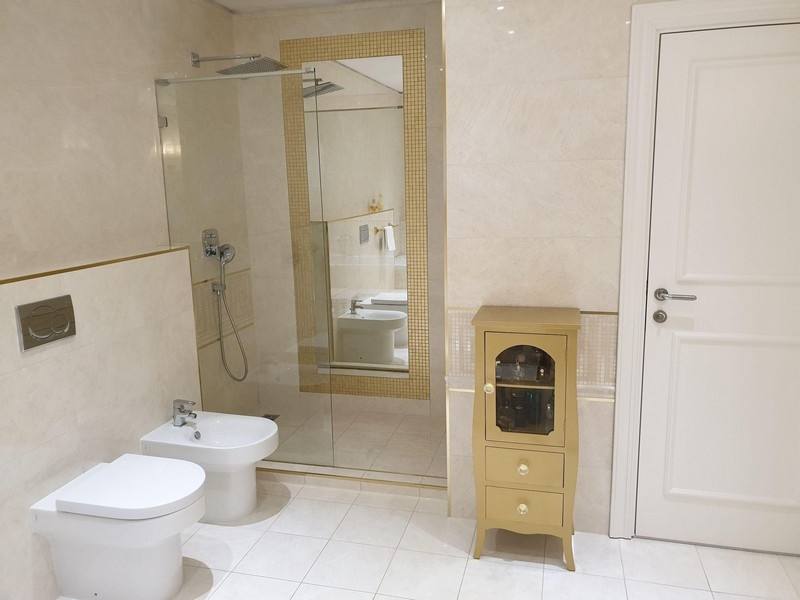 Badrum med dusch, bidé och ljust klinkergolv