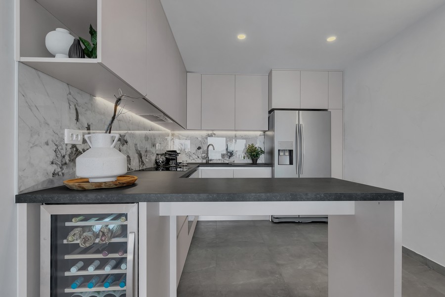 Modernt utrustat kök med ö och vinkyl