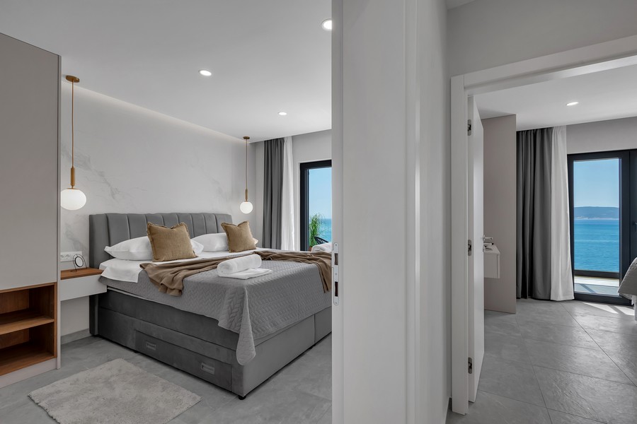 Sovrum med dubbelsäng och balkong mot havet