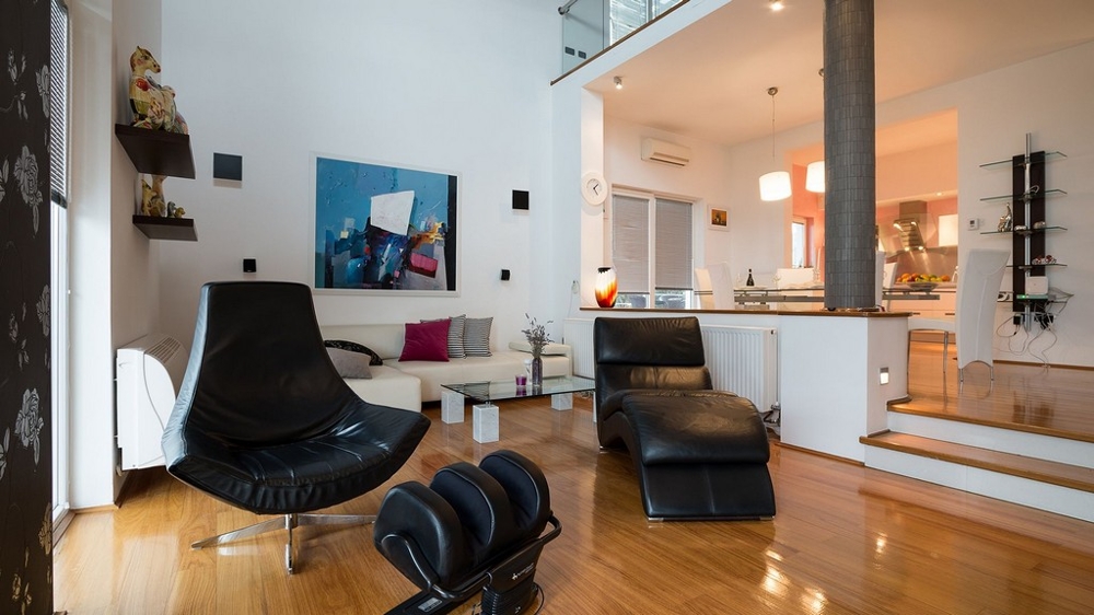 Vardagsrum med skinnfåtöljer och öppet kök