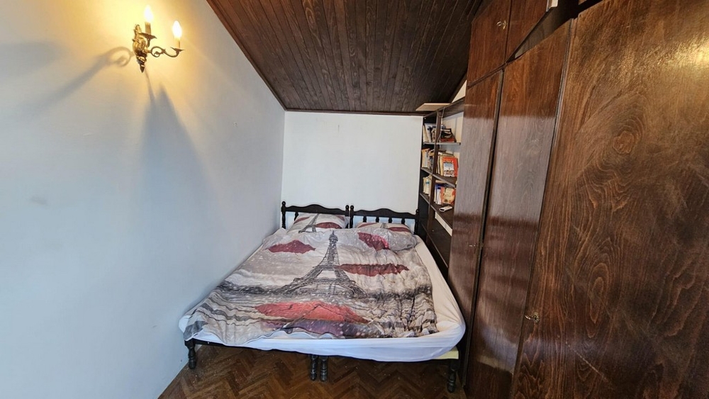 Sovrum med dubbelsäng och trätak