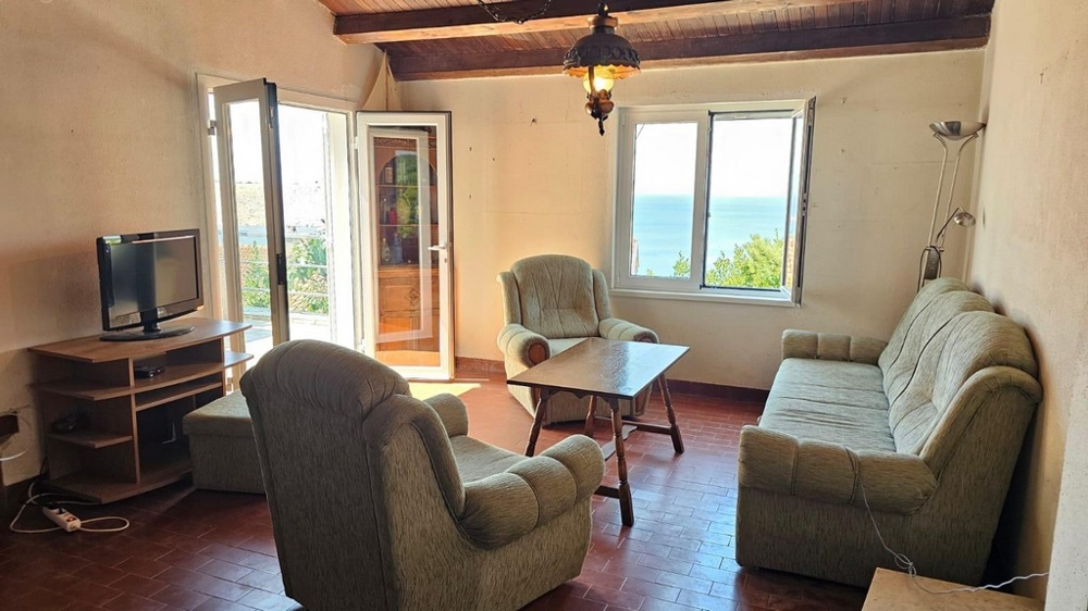 Vardagsrum med utgång till terrassen och havsutsikt