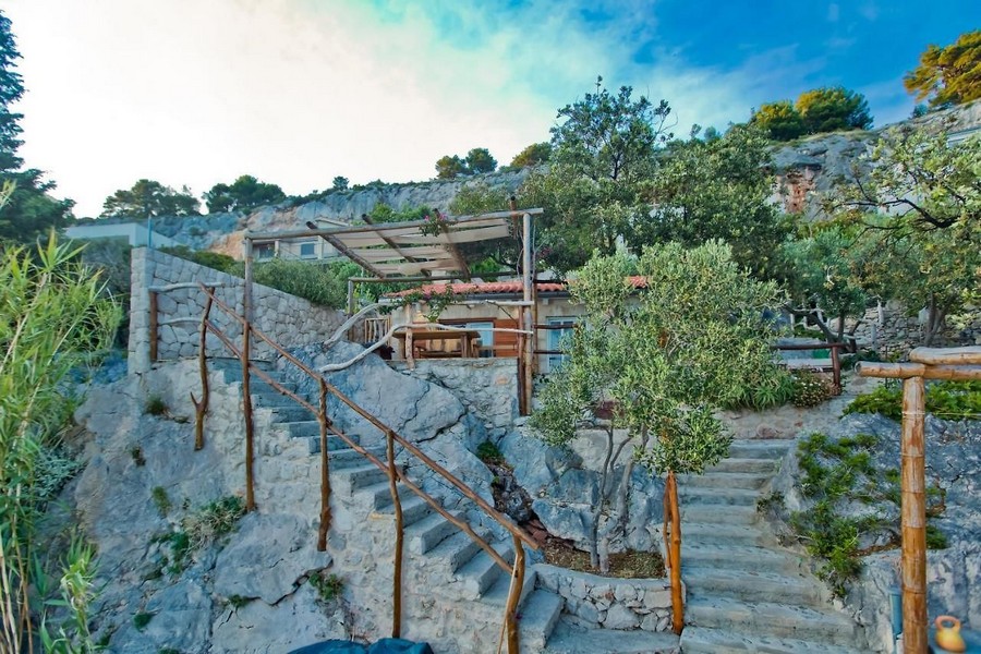 Stentrappa till huset på sluttningen med en täckt terrass