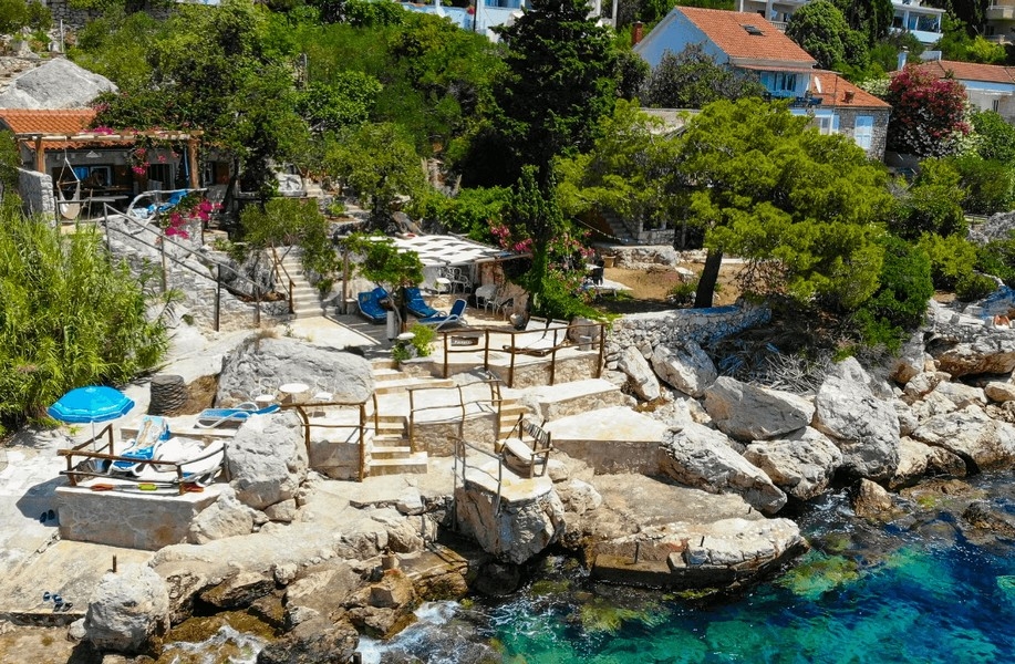 Stenigt kustområde med solplatser och direkt tillgång till havet