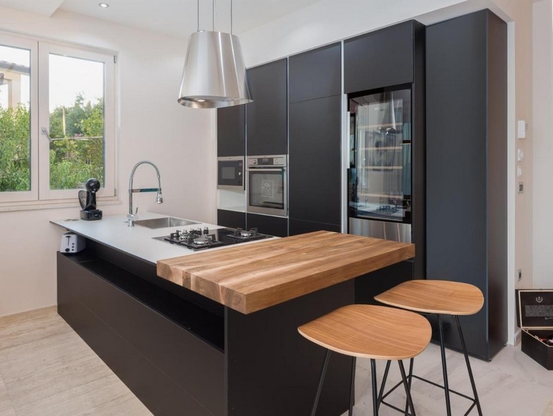 Modernt svart kök med ö och träbänk