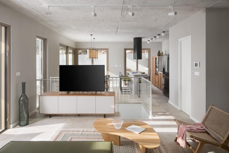 Ljust vardagsrum med TV och öppet kök