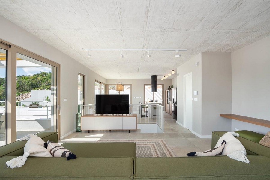 Vardagsrum med soffa och utsikt över köket