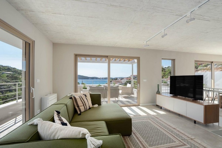 Vardagsrum med soffa och utgång till terrassen med havsutsikt