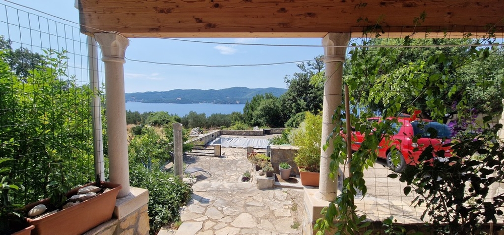 Täckt terrass med utsikt över den täckta poolen och havet.