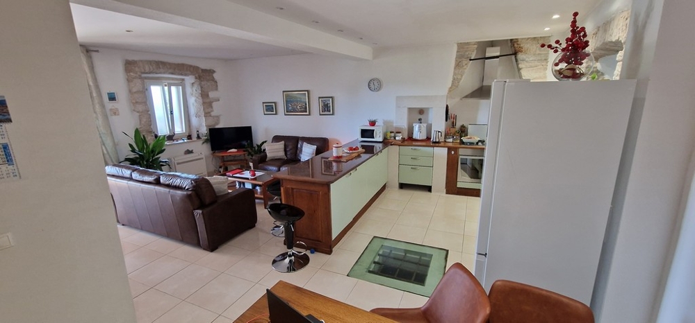 Öppen vardagsrumsdel med kök och sittgrupp