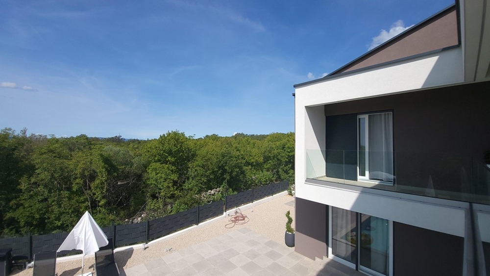 Modern villa med terrass och glasräcken