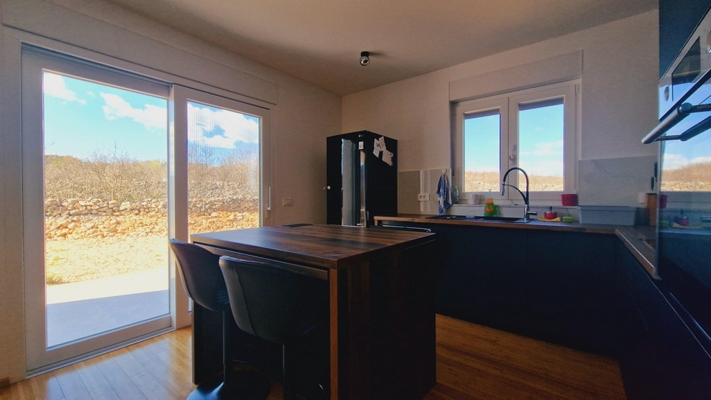 Modernt kök med köksö och tillgång till trädgården