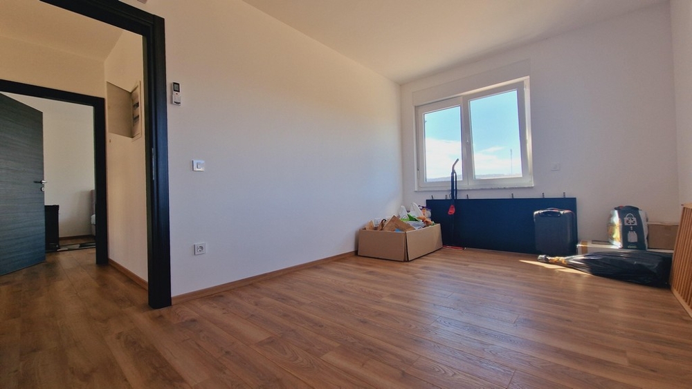 Ljust rum med parkettgolv och två fönster