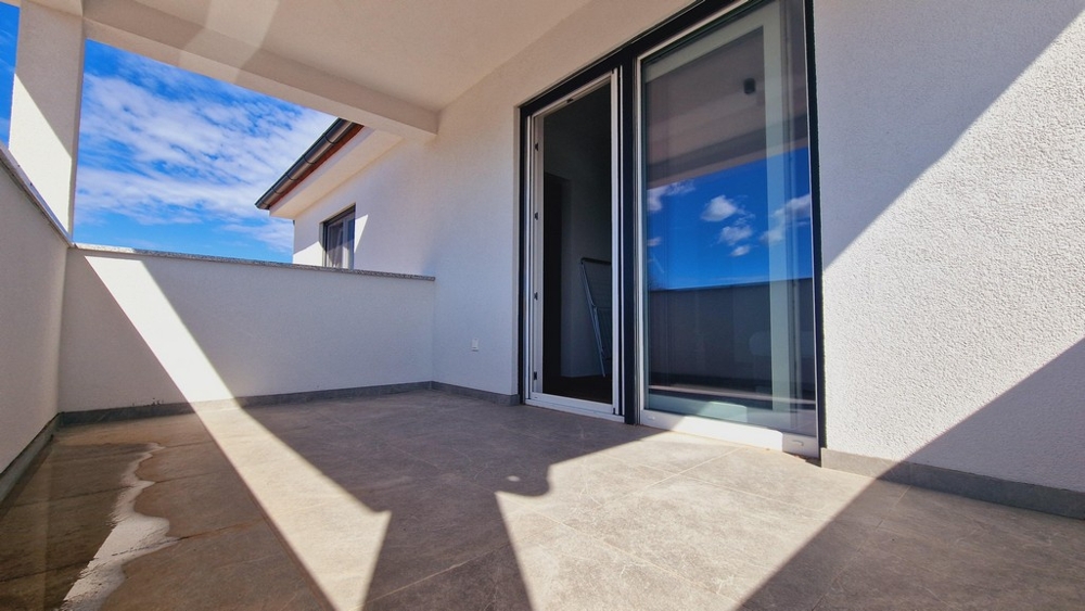 Täckt terrass på övervåningen med havsutsikt