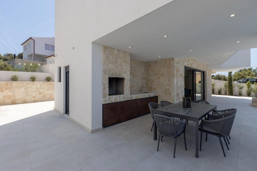 Täckt terrass med grill och matbord