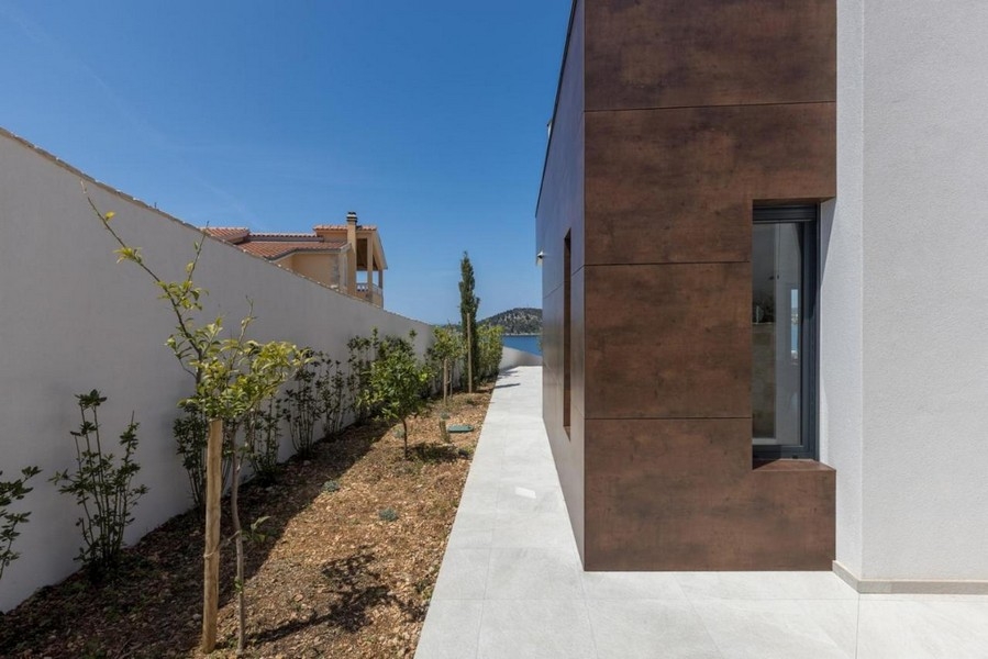 Sidovy av villan med trädgårdsgång och havsutsikt