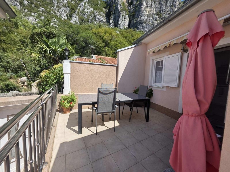 Terrass med bord, stolar och utsikt över klipporna