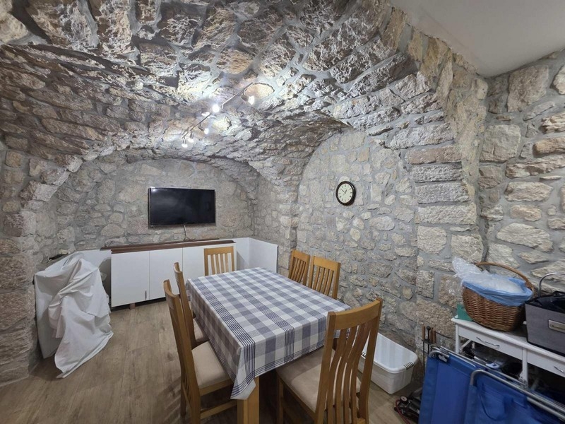 Tegelstenskrog med träbord och stolar