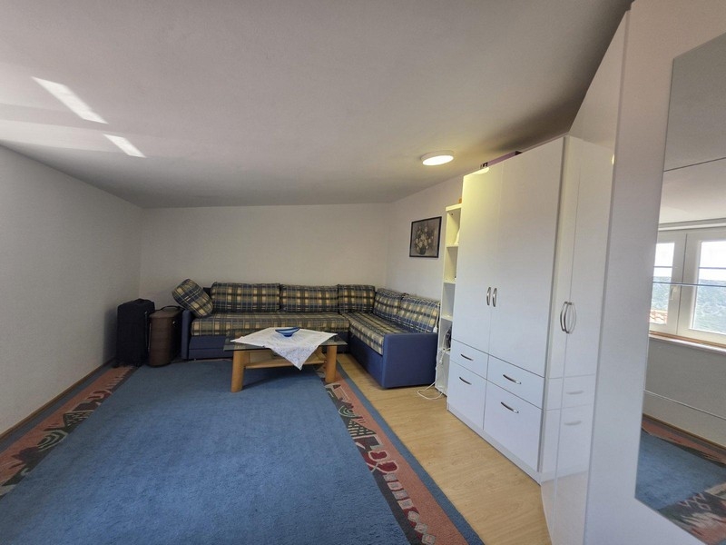 Vardagsrum med hörnsoffa, matta och skåp