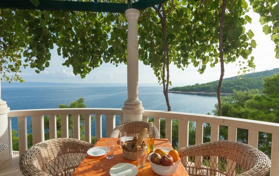 Täckt terrass med sittplatser och havsutsikt