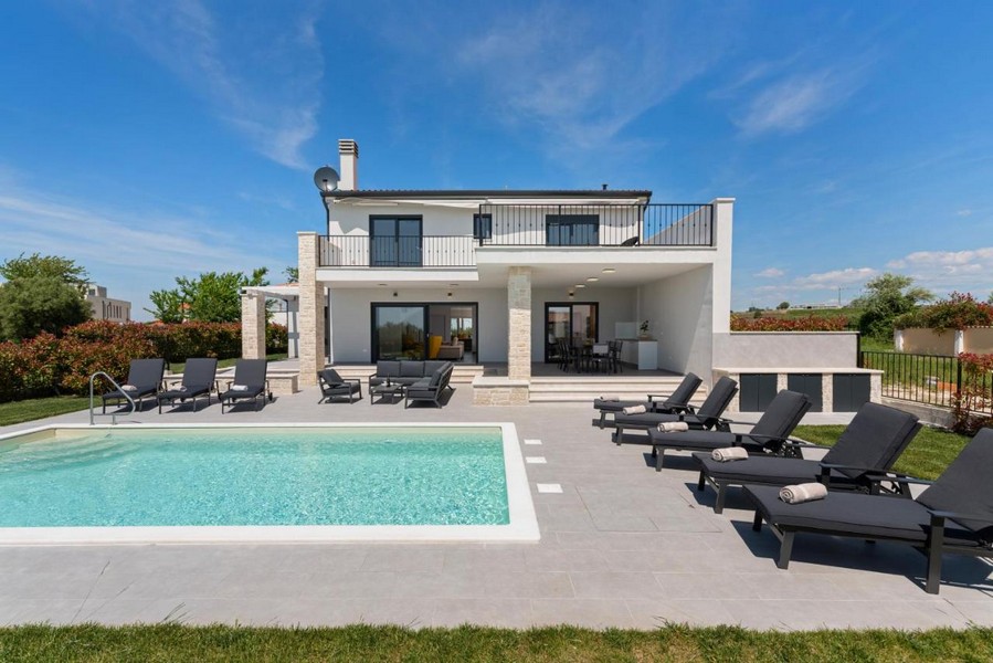 Exteriör vy av villan med pool och solterrass