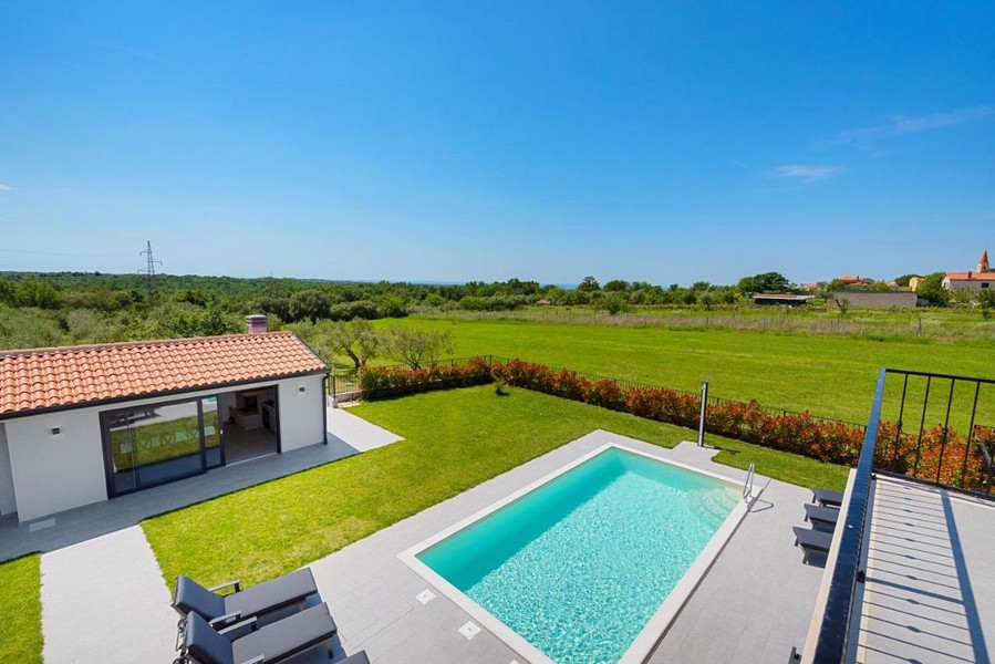 Utsikt över grönskan och poolen på fastigheten H3675 i Istrien.