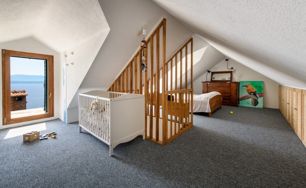 Vindsvåning med spjälsäng och havsutsikt